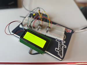 An Adafruit Metro, 20x4 LCD character display, and a couple of potentiometers breadboarded together. The display shows the text 'D Dorian.'